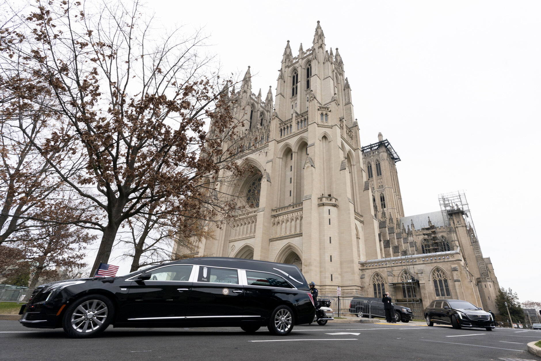 The hearse carrying the flag-draped casket of former Sen. Bob Dole of Kansas, leaves the Washington National Cathedral following a funeral service, Friday, Dec. 10, 2021, in Washington. (AP Photo/Manuel Balce Ceneta)