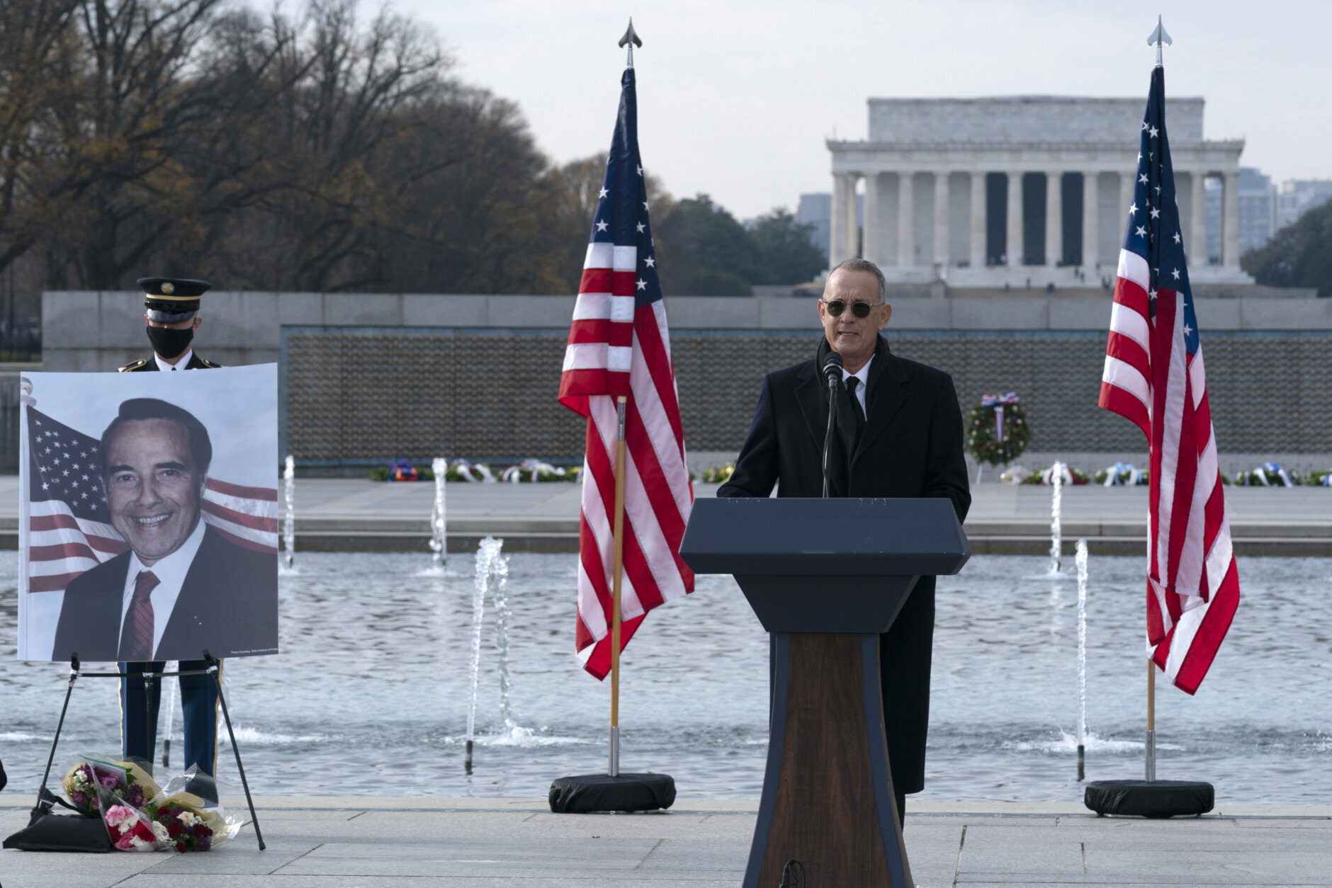 With the Lincoln Memorial in the background, actor and filmmaker Tom Hanks speaks during a ceremony to honor former Sen. Bob Dole, R-Kan., at the National World War II Memorial, on Friday, Dec. 10, 2021, in Washington. (AP Photo/Jose Luis Magana)