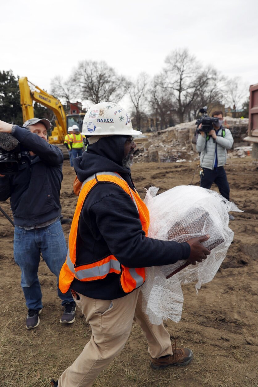 Michael Spence, construction superintendent with Team Henry Enterprises, moves a box believed to be the 1887 time capsule that was put under Confederate Gen. Robert E. Lee statue's pedestal and recovered on Monday, Dec. 27, 2021, in Richmond, Va. (Eva Russo/Richmond Times-Dispatch via AP)