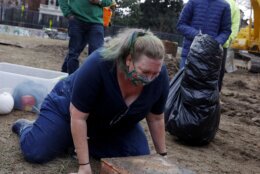 <p>Katherine Ridgway, state archaeological conservator, prepares to wrap and remove a box believed to be the 1887 time capsule that was put under Confederate Gen. Robert E. Lee statue&#8217;s pedestal Monday, Dec. 27, 2021, in Richmond, Va. In back, Everett Mercer, 10, son of Governor Ralph Northam&#8217;s chief staff Clark Mercer, stands by to help. Crews wrapping up the removal Monday of the giant pedestal that once held a statue of Gen. Lee found what appeared to be a second and long-sought-after time capsule, Virginia Gov. Ralph Northam said. (Eva Russo/Richmond Times-Dispatch via AP)</p>
