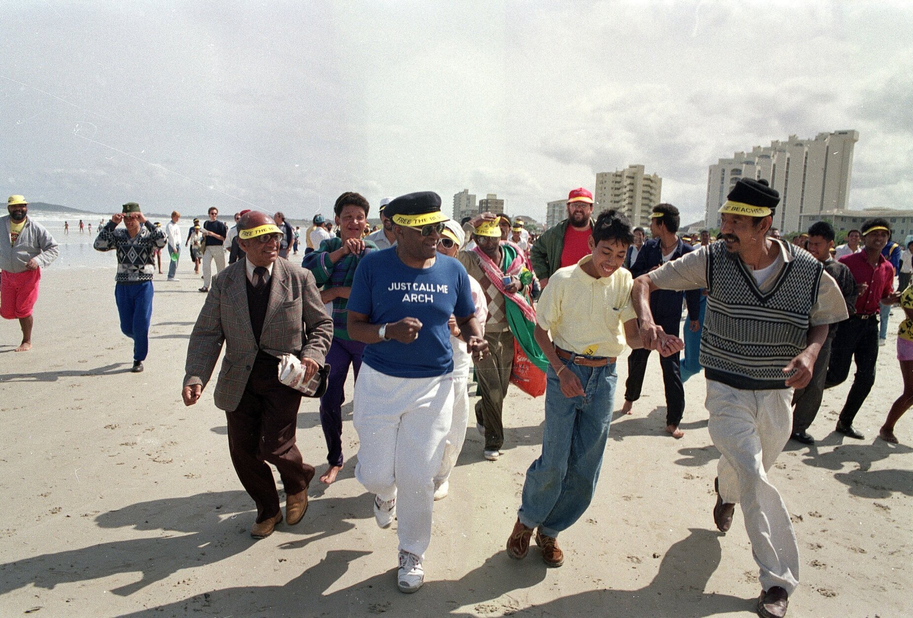 <p>In this 1989 photo, then-Anglican Archbishop of Cape Town Desmond Tutu (center) jogs along a whites-only beach with a crowd of supporters near Cape Town, South Africa, as church organizations continued their campaign of defiance against apartheid laws.</p>
