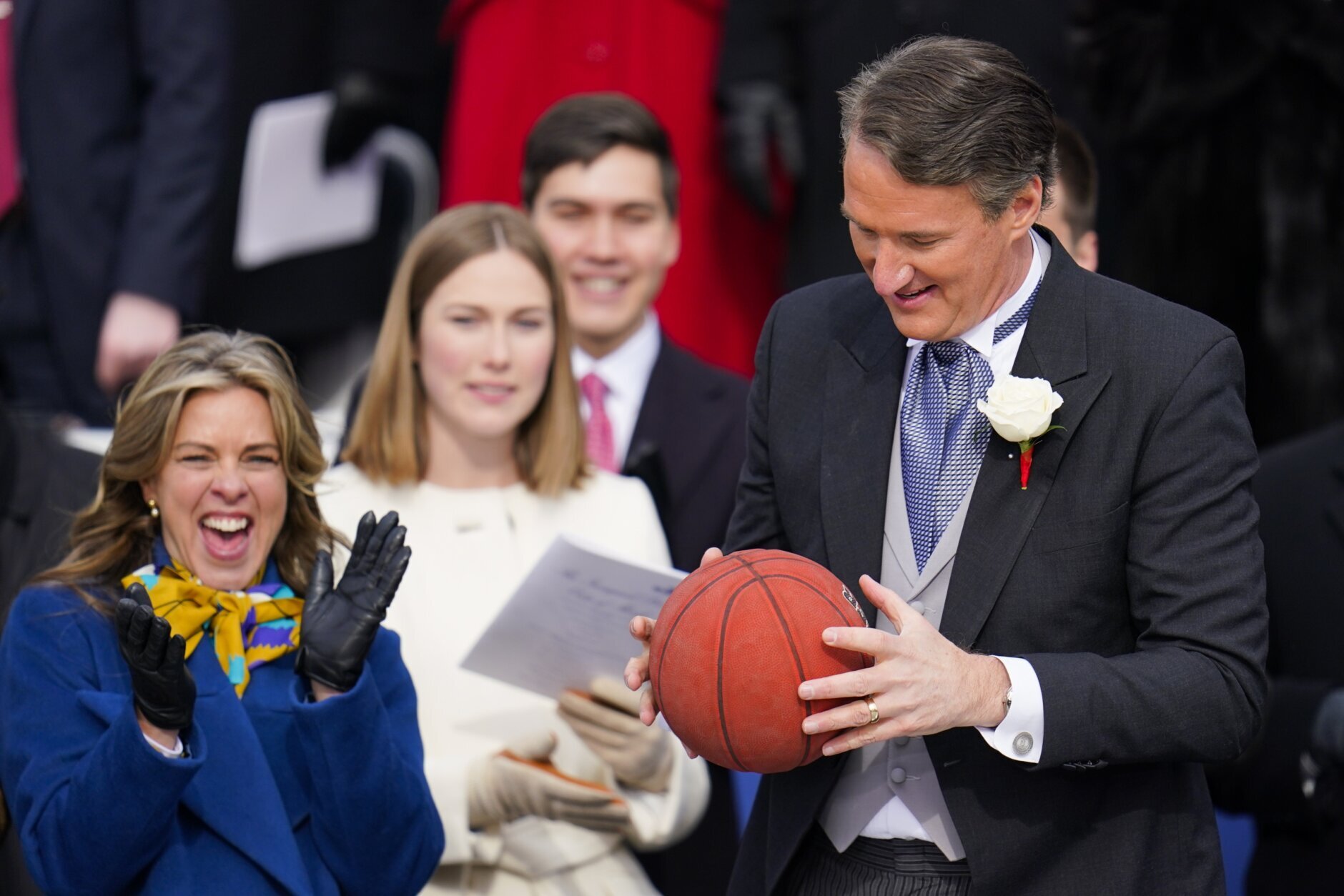 Virginia Gov. Glenn Youngkin holds a basketball tossed to him by the members of Norfolk Academy basketball team during a parade after he was sworn in during the gubernatorial inauguration ceremony, Saturday, Jan. 15, 2022, in Richmond, Va. (AP Photo/Julio Cortez)