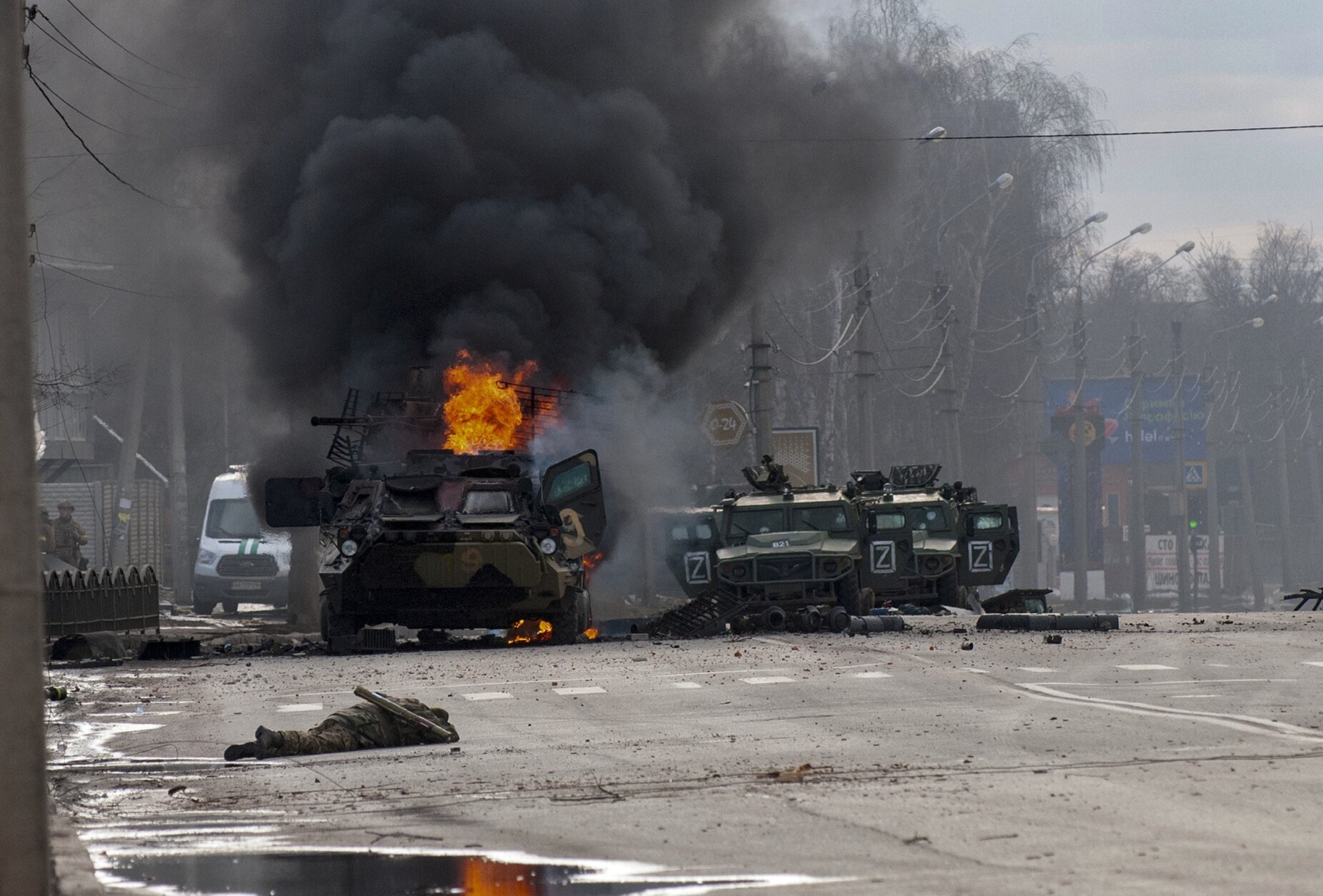 ADDS THAT THE PERSONNEL CARRIER IS RUSSIAN - A Russian armored personnel carrier burns amid damaged and abandoned light utility vehicles after fighting in Kharkiv, Ukraine, Sunday, Feb. 27, 2022. The city authorities said that Ukrainian forces engaged in fighting with Russian troops that entered the country's second-largest city on Sunday. (AP Photo/Marienko Andrew)