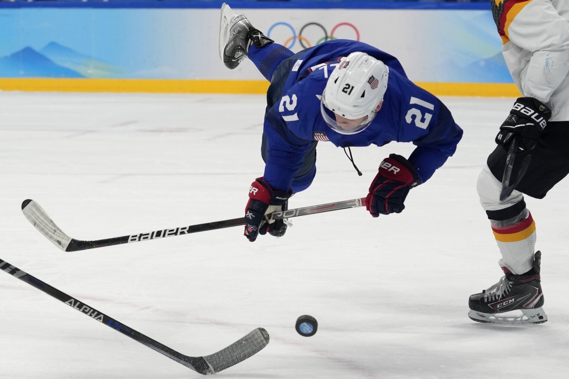 <p>United States&#8217; Brian O&#8217;Neill falls as he goes for the puck during a preliminary round men&#8217;s hockey game against Germany at the 2022 Winter Olympics, Sunday, Feb. 13, 2022, in Beijing.</p>
