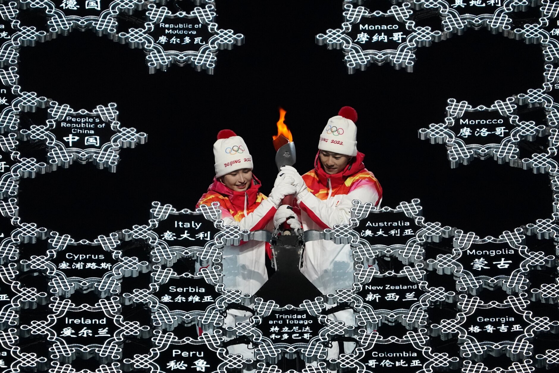 China's athletes Dinigeer Yilamujian and Zhao Jiawen light the cauldron during the opening ceremony of the 2022 Winter Olympics, Friday, Feb. 4, 2022, in Beijing. (AP Photo/Jae C. Hong)