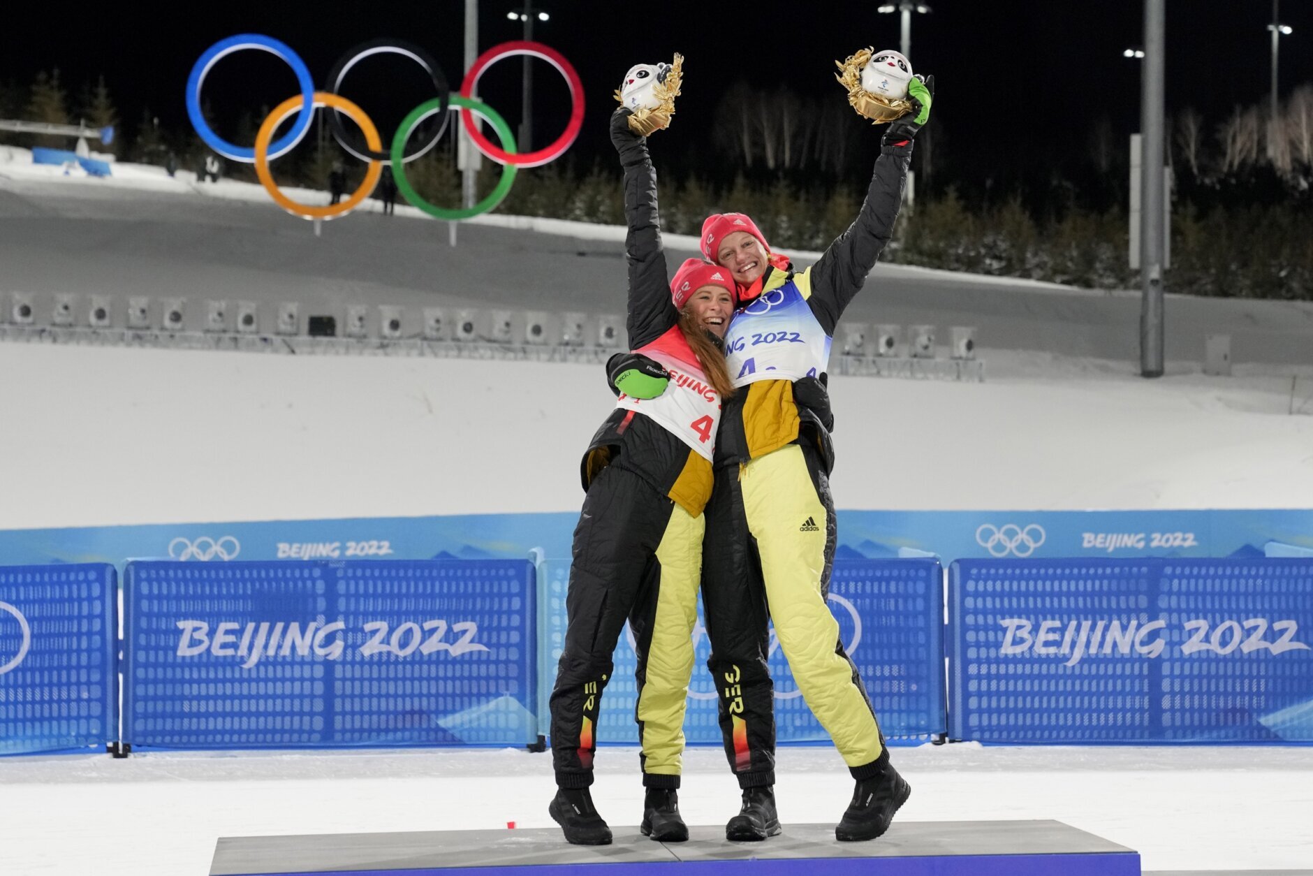 <p>Gold medal finishers Katharina Hennig, of Germany, left, and Victoria Carl, of Germany, celebrate during a venue ceremony after the women&#8217;s team sprint classic cross-country skiing competition at the 2022 Winter Olympics, Wednesday, Feb. 16, 2022, in Zhangjiakou, China.</p>

