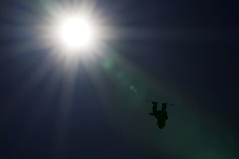 GLIMPSES: Silhouetted, Olympic snowboarder hangs in mid-air