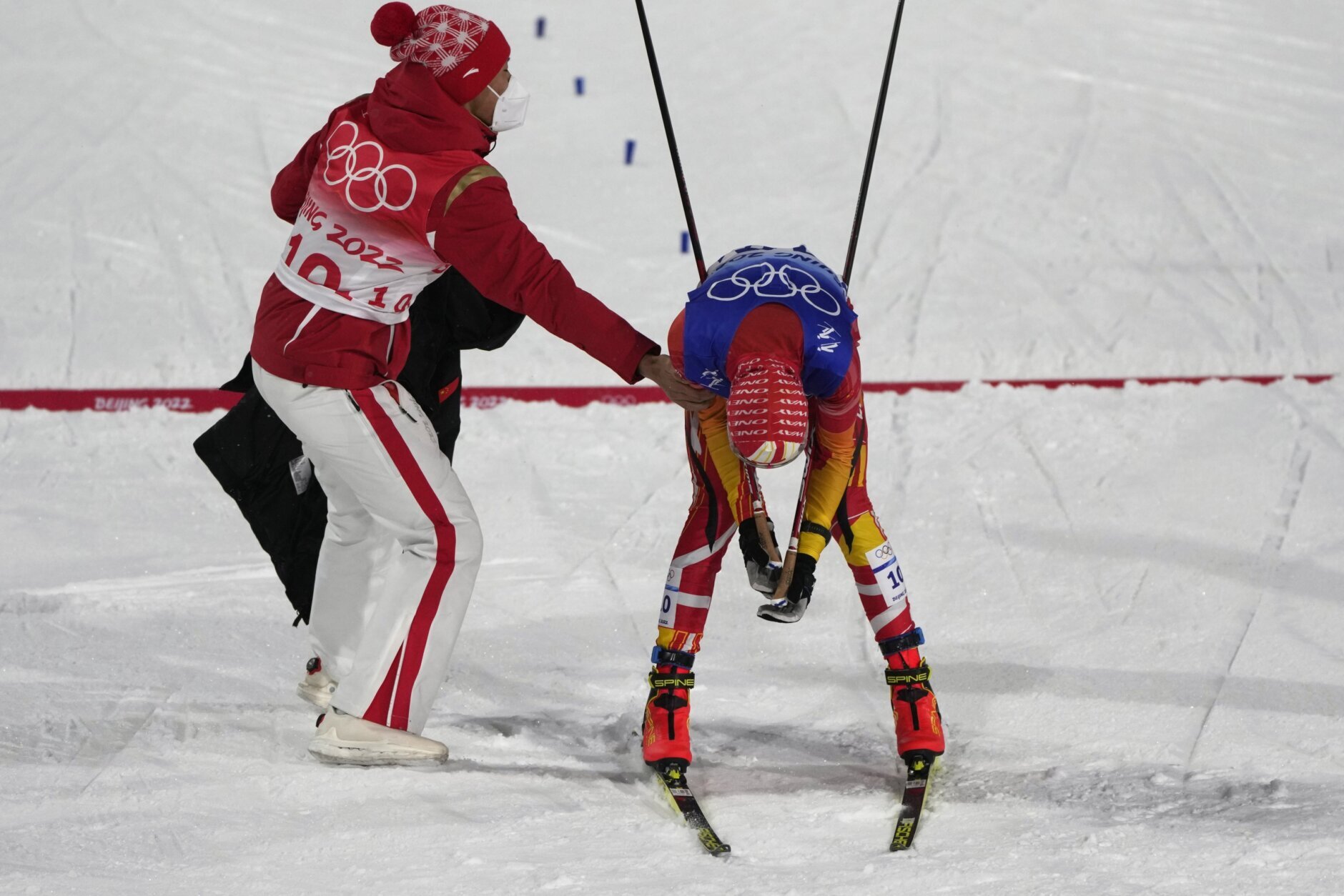 China's Zhao Jiawen, left, greets China's Fan Haibin at the finish line after the cross-country skiing competition of the team Gundersen large hill/4x5km at the 2022 Winter Olympics, Thursday, Feb. 17, 2022, in Zhangjiakou, China. (AP Photo/Alessandra Tarantino)