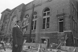 FILE - Rev. John Cross points to the wreckage of the 16th Street Baptist Church in Birmingham, Ala., Sept. 19, 1963. The church was damaged heavily by a bomb blast on Sunday, Sept. 15, which killed four young girls and injured many others. Workmen have begun repairing the damage. Threats against Black institutions are deeply rooted in U.S. history and leaders say the history of violence against people of color should be passed on to new generations so the lessons of the past can be applied to the present. (AP Photo, File)