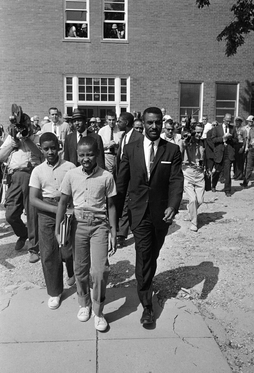 FILE - Rev. Fred Shuttlesworth right, integration leader, escorts Dwight Armstrong, 9, and his brother Floyd, 11, from the Graymont Elementary School in Birmingham, Ala, Sept. 9, 1963. State troopers, on order from the governor, opened the school but turned the African Americans away. Threats against Black institutions are deeply rooted in U.S. history and leaders say the history of violence against people of color should be passed on to new generations so the lessons of the past can be applied to the present. (AP Photo, File)