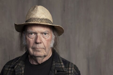 Neil Young back on at the Glastonbury music festival, citing ‘an error in the information received’