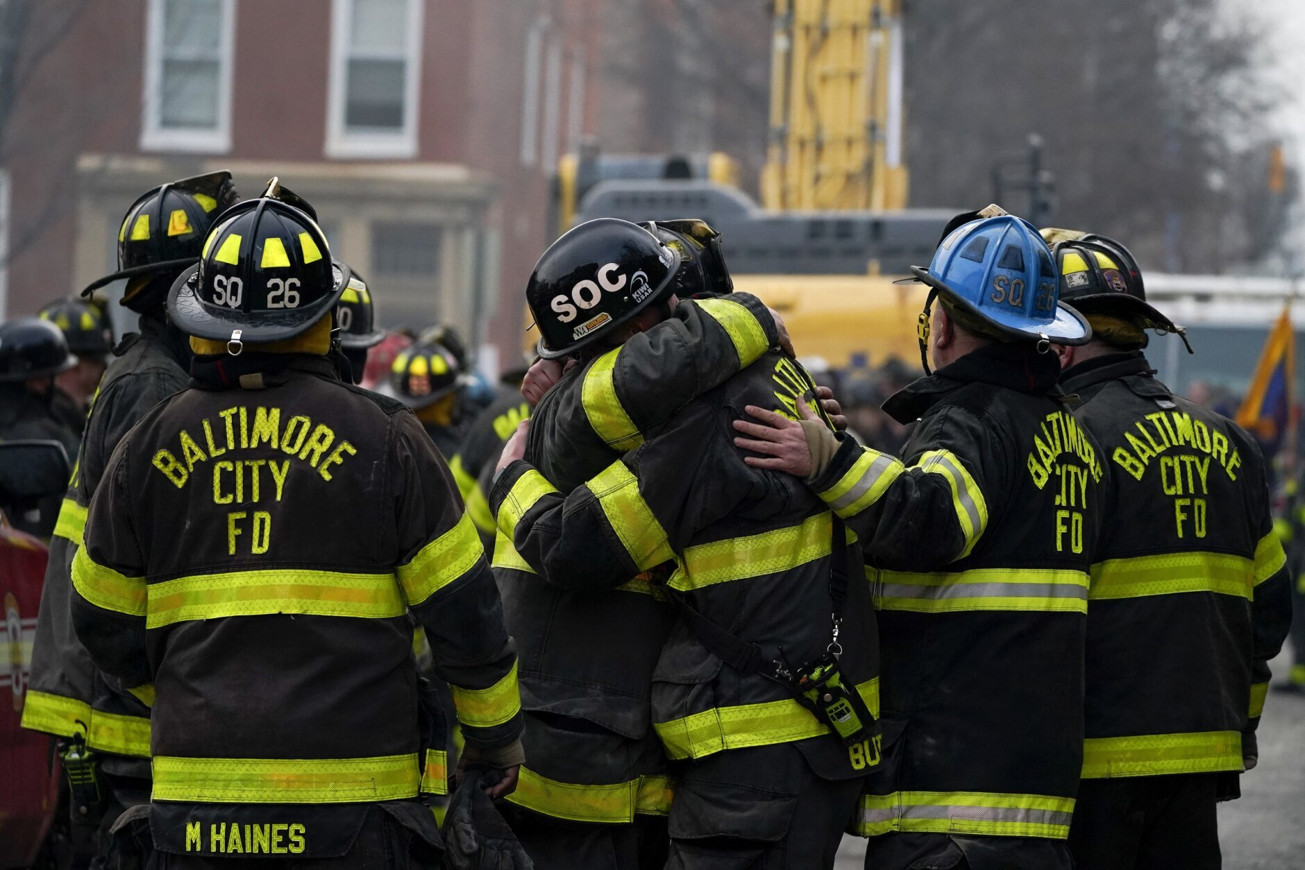 FILE - Firefighters embrace each other after a deceased firefighter was pulled out of a building collapse while battling a two-alarm fire in a vacant row home, Monday, Jan. 24, 2022, in Baltimore. Officials said several firefighters died during the blaze. The U.S. Census estimates there are 17 million vacant homes across the U.S. (AP Photo/Julio Cortez, File)