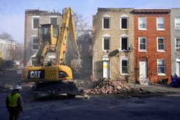 FILE - An excavator is used to pull debris off a building during efforts to retrieve the body of a deceased firefighter caught in the building's collapse while battling a two-alarm fire in the vacant row home, Monday, Jan. 24, 2022, in Baltimore. Officials said several firefighters died during the blaze. The U.S. Census estimates there are 17 million vacant homes across the U.S. (AP Photo/Julio Cortez, File)