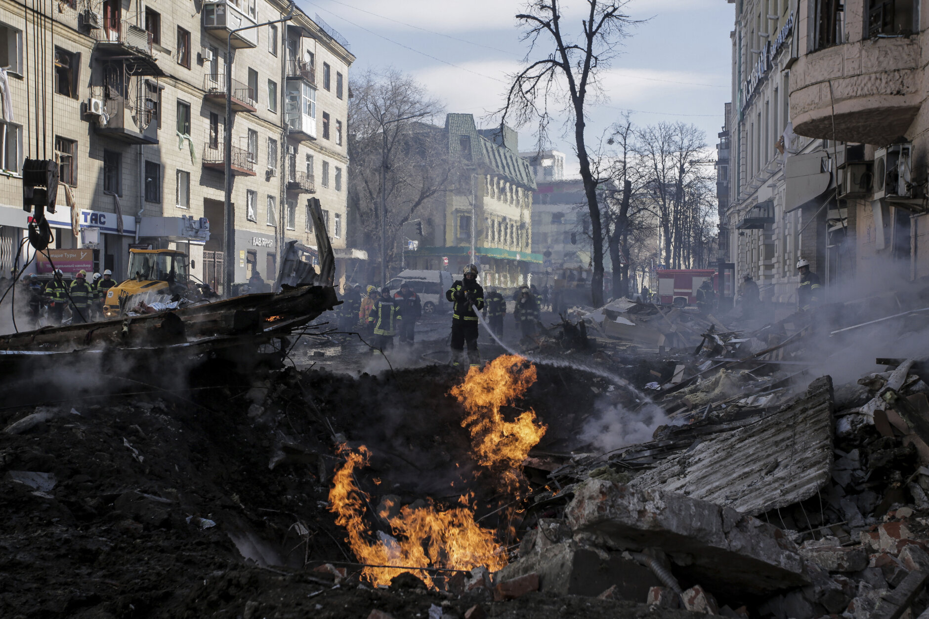 <p>Firefighters extinguish flames outside an apartment house after a Russian rocket attack in Kharkiv, Ukraine&#8217;s second-largest city, Ukraine, Monday, March 14, 2022.</p>
