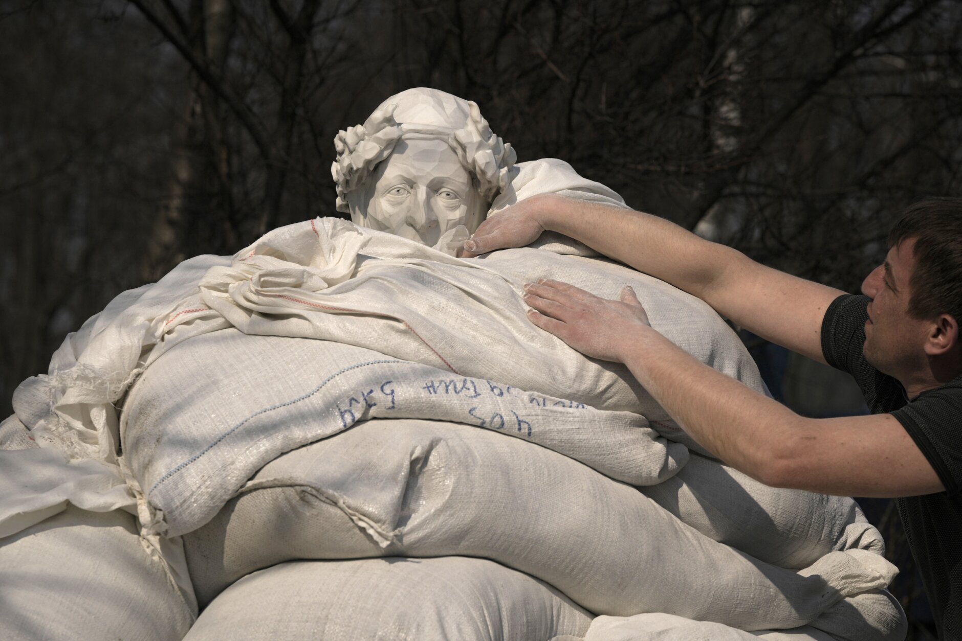 Municipal workers finish covering a statue of Italian poet and philosopher Dante Alighieri with sandbags to protect it from potential damage from shelling, in Kyiv, Ukraine, Wednesday, March 23, 2022. The statue, by sculptor Luciano Massari, was inaugurated in 2015 to mark 750 years since Dante's birth. (AP Photo/Vadim Ghirda)