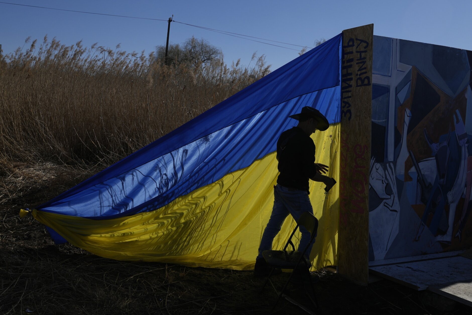Roberto Marquez, a volunteer from Mexico, makes an installation with the Ukrainian flag in Medyka, southeastern Poland, on Wednesday, March 23, 2022. Poland has received more than 2 million Ukrainian refugees since the Feb. 24 invasion. (AP Photo/Sergei Grits)