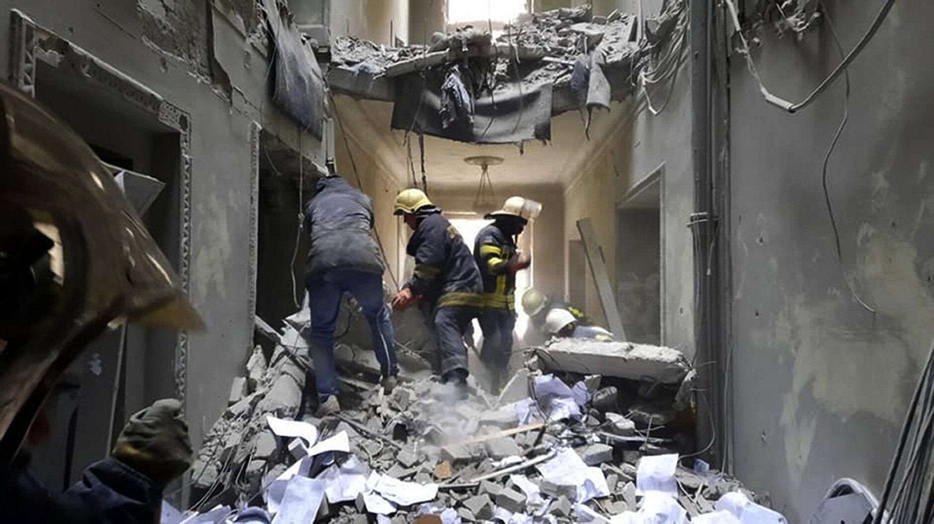 This handout photo released by Ukrainian Emergency Service shows emergency service personnel inspecting the damage inside the City Hall building in Kharkiv, Ukraine, Tuesday, March 1, 2022. Russian shelling pounded civilian targets in Ukraine's second-largest city, Kharkiv, Tuesday and a 40-mile convoy of tanks and other vehicles threatened the capital — tactics Ukraine's embattled president said were designed to force him into concessions in Europe's largest ground war in generations. (Ukrainian Emergency Service via AP)