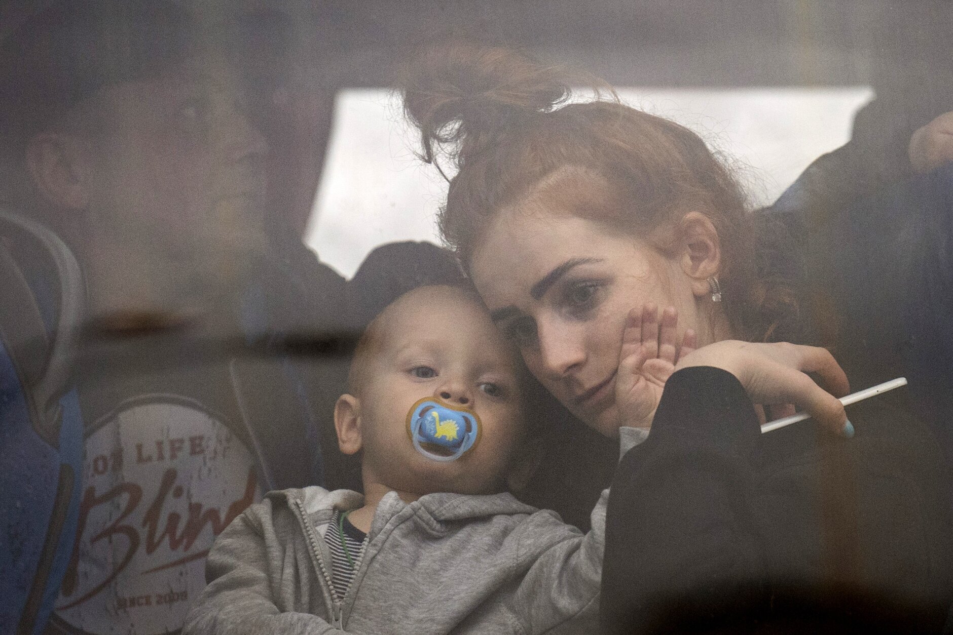 A woman holds her baby inside a bus as they leave Kyiv, Ukraine, Thursday, Feb. 24, 2022. (AP Photo/Emilio Morenatti)