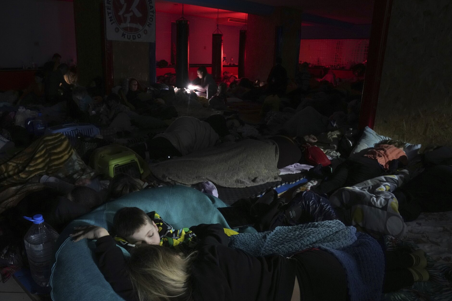 People sleep in the improvised bomb shelter in a sports center, which can accommodate up to 2000 people, in Mariupol, Ukraine, late Sunday, Feb. 27, 2022. (AP Photo/Evgeniy Maloletka)