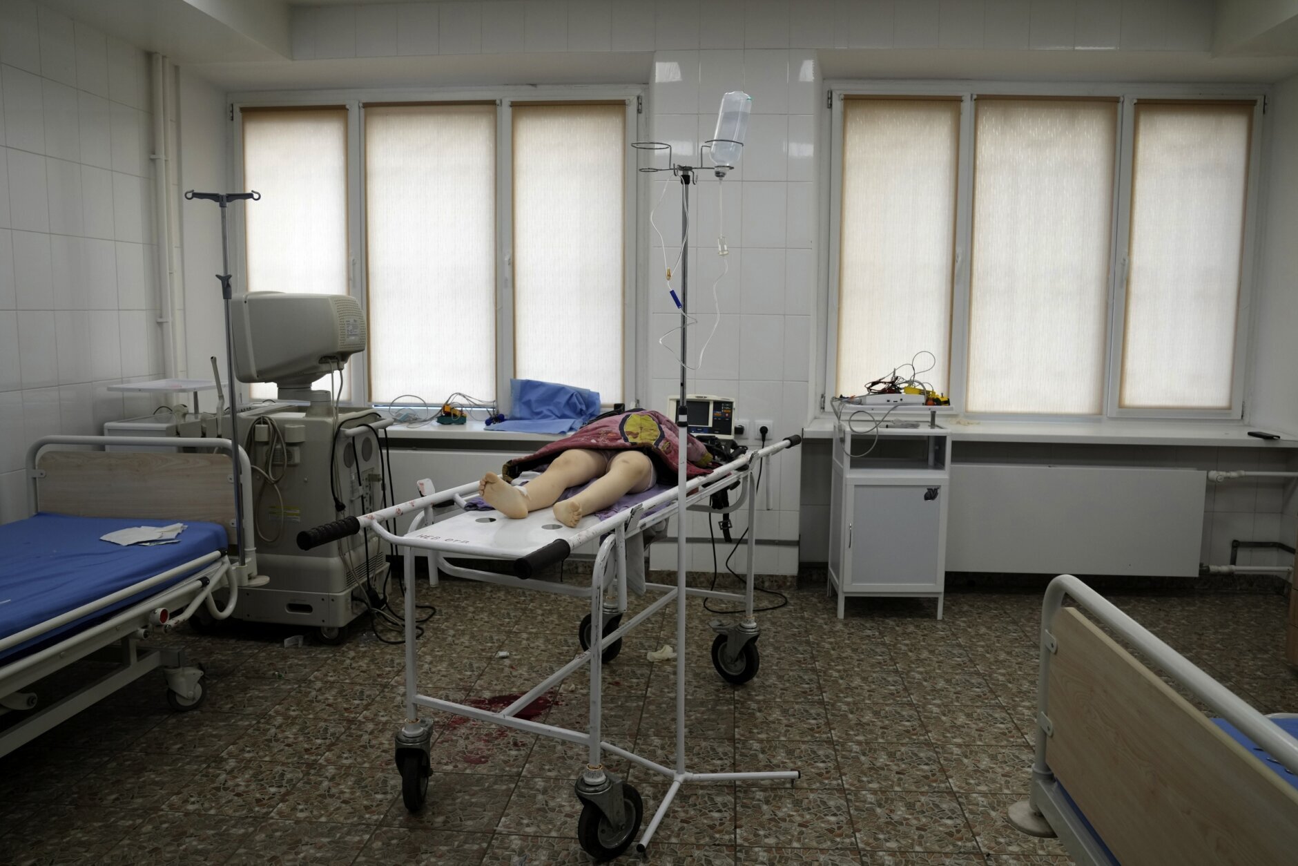 The lifeless body of a girl killed during the shelling of a residential area lies on a medical cart at the city hospital of Mariupol, eastern Ukraine, Sunday, Feb. 27, 2022. (AP Photo/Evgeniy Maloletka)