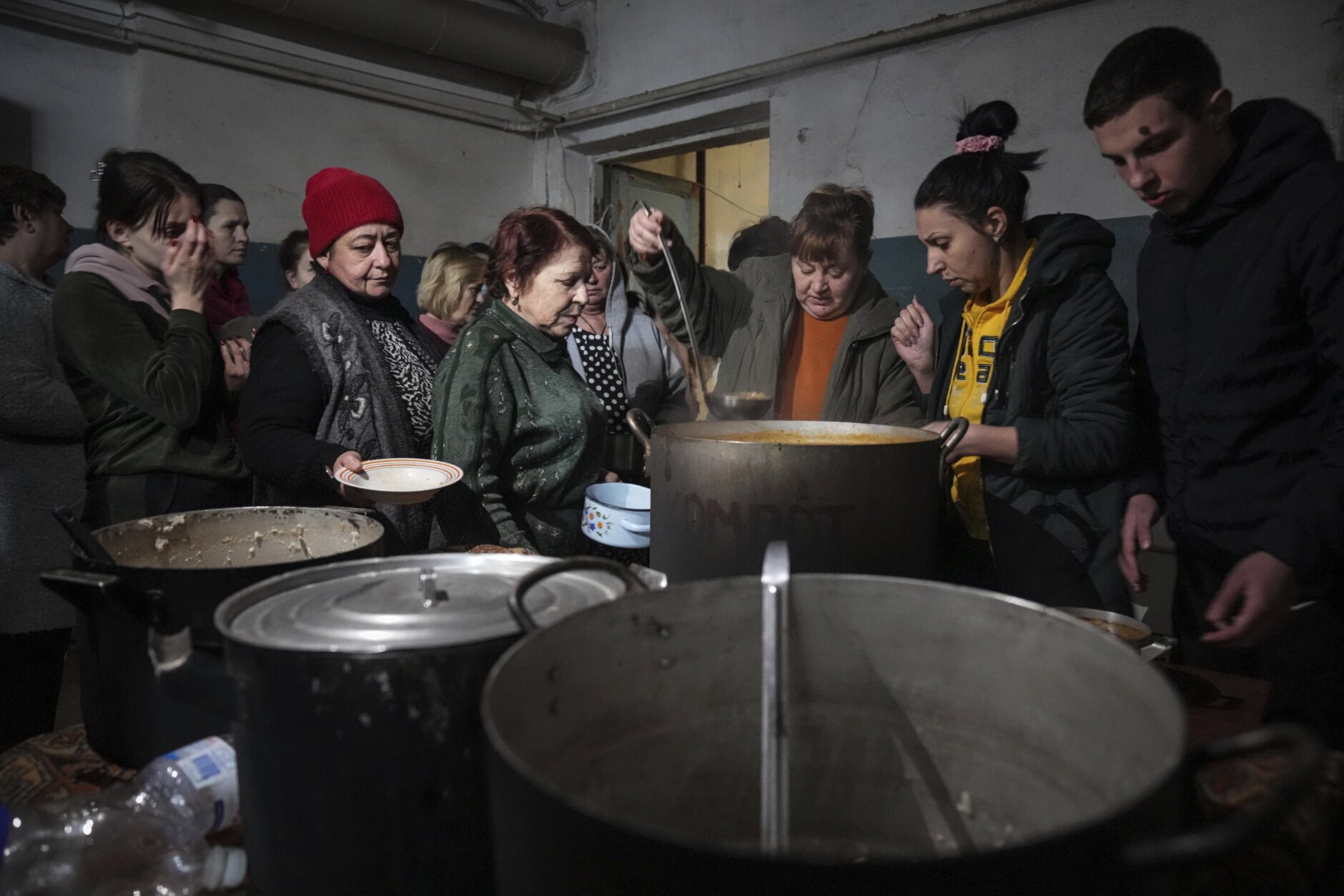 <p>People queue to receive hot food in a improvised bomb shelter in Mariupol, Ukraine, Monday, March 7, 2022. (AP Photo/Evgeniy Maloletka)</p>

