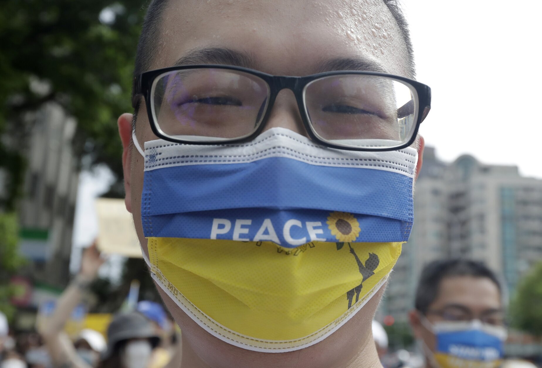 A Taiwanese man wears a Ukraine national flag-patterned mask in protest against the invasion of Russia during a march in Taipei, Taiwan, Sunday, March 13, 2022. (AP Photo/Chiang Ying-ying)