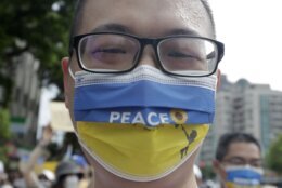 A Taiwanese man wears a Ukraine national flag-patterned mask in protest against the invasion of Russia during a march in Taipei, Taiwan, Sunday, March 13, 2022. (AP Photo/Chiang Ying-ying)