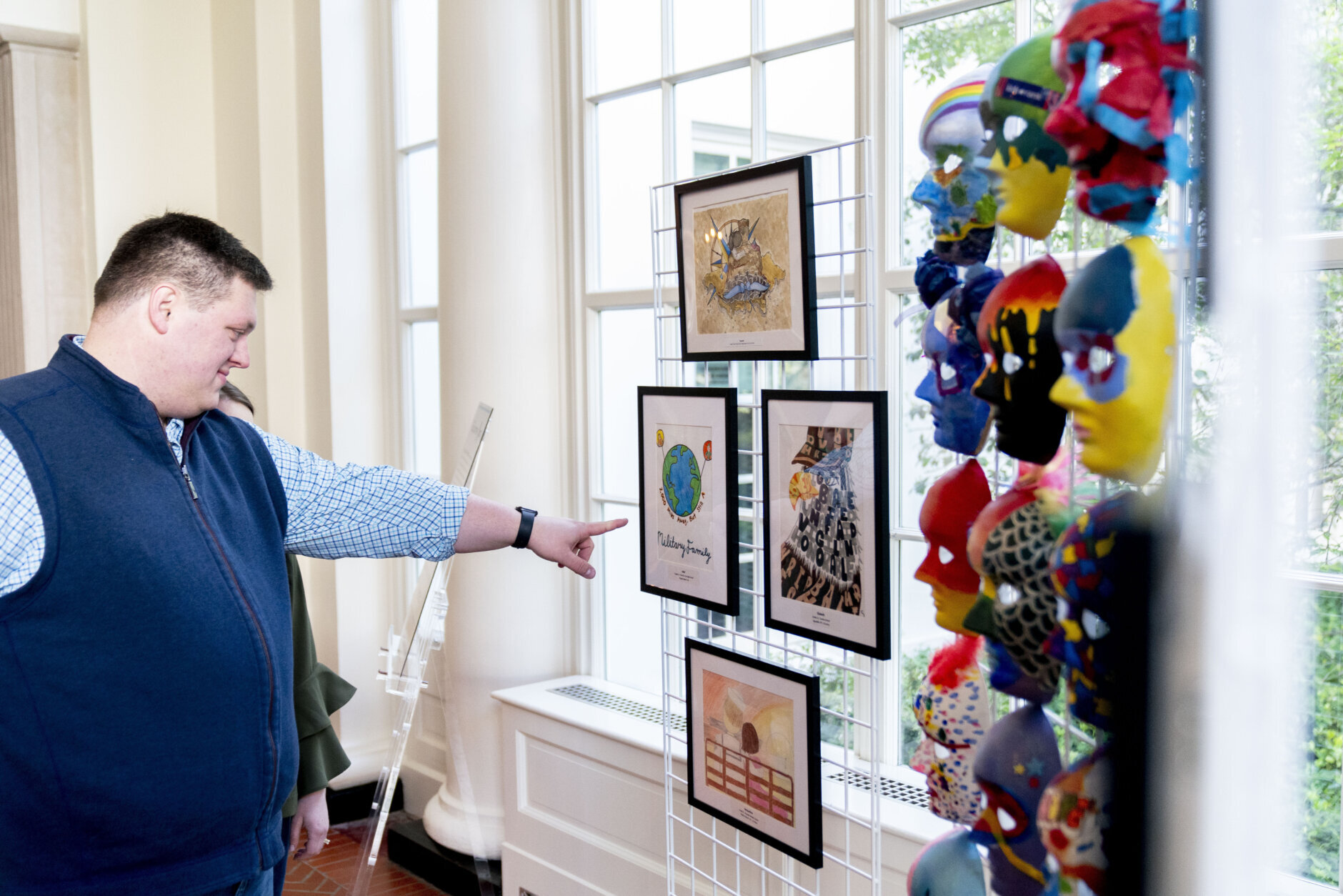 A visitor looks at artwork by military connected children on display along the public tour route at the White House in Washington, Friday, April 29, 2022, First lady Jill Biden has added a temporary installation in the East Wing of more then 20 pieces of artwork from military children across the country and those stationed around the world.in honor of the Month of the Military Child. (AP Photo/Andrew Harnik)