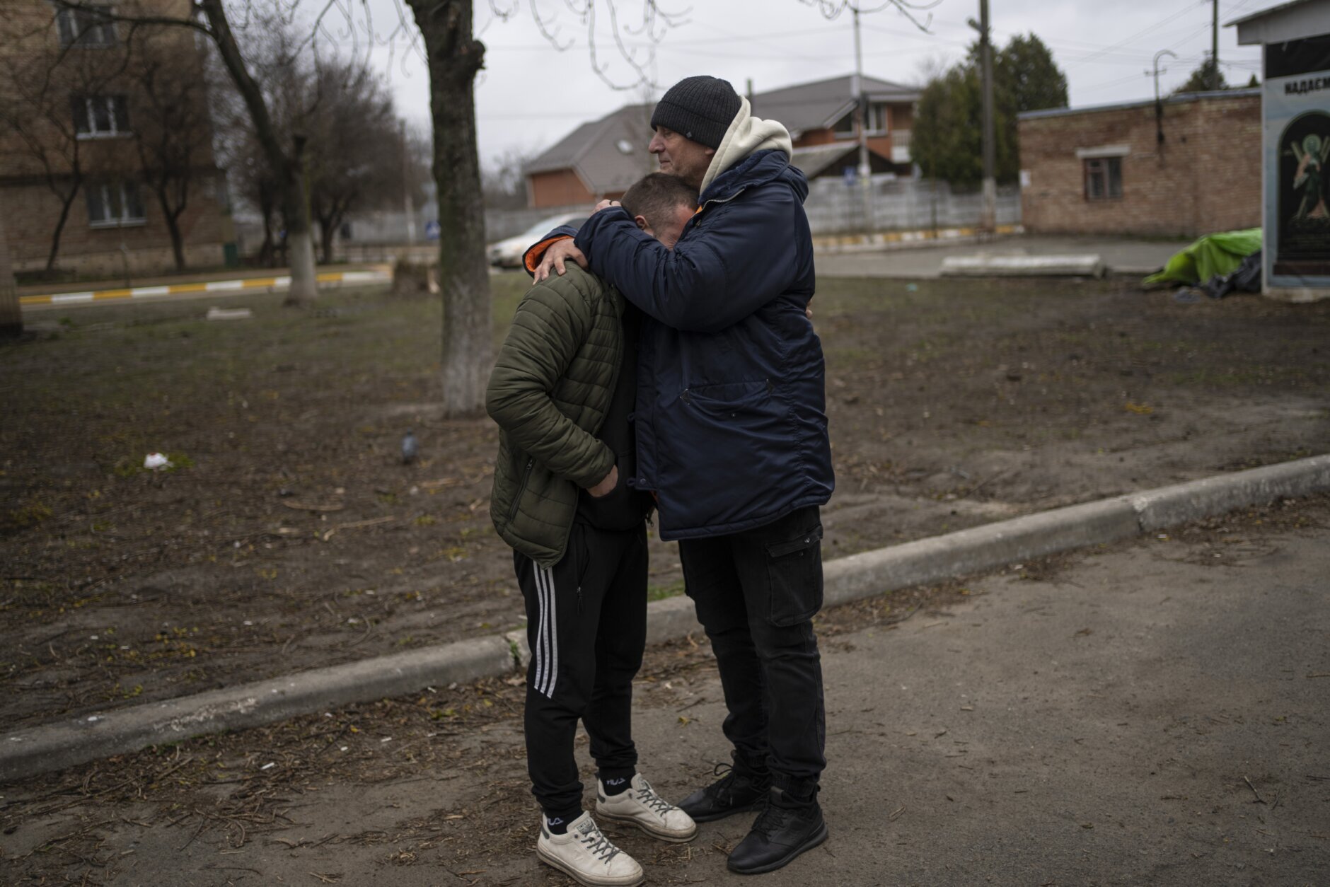 The father and a friend of Anatoliy Kolesnikov, 30, who was killed by Russian soldiers in his car trying to evacuate from Irpin, mourns his death while waiting outside the morgue in Bucha, in the outskirts of Kyiv, Ukraine, Wednesday , April 13, 2022. (AP Photo/Rodrigo Abd)