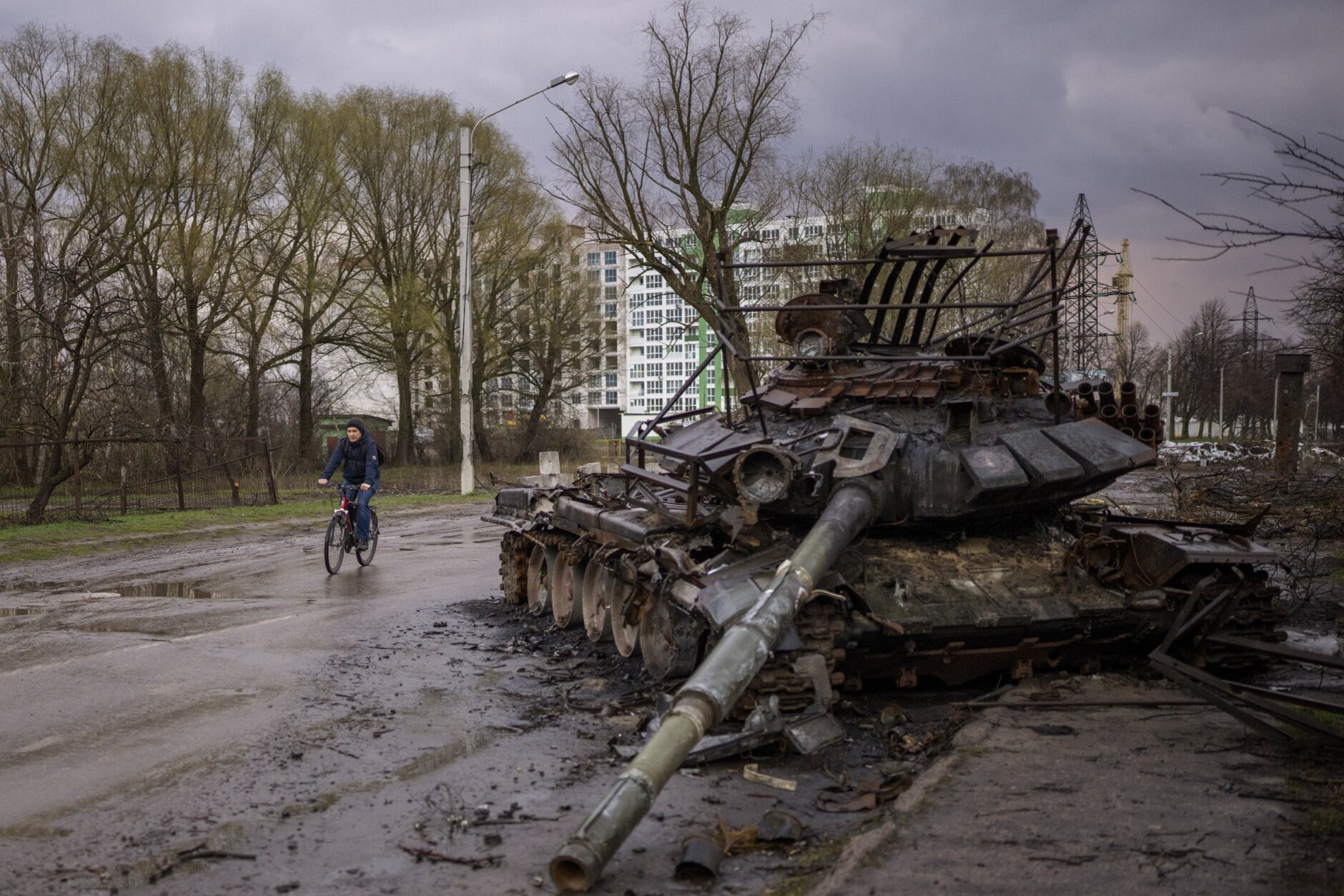 A man rides his bicycle next to a destroyed Russian tank in Chernihiv, Ukraine, on Thursday, April 21, 2022. (AP Photo/Emilio Morenatti)