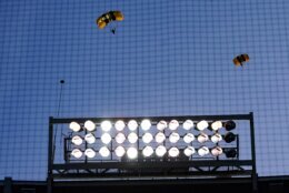 The U.S. Army Parachute Team the Golden Knights descend into National Park before a baseball game between the Washington Nationals and the Arizona Diamondbacks Wednesday, April 20, 2022, in Washington. The U.S. Capitol was briefly evacuated after police said they were tracking an aircraft “that poses a probable threat,” but the plane turned out to be the military aircraft with people parachuting out of it for a demonstration at the Nationals game, officials told The Associated Press. (AP Photo/Alex Brandon)