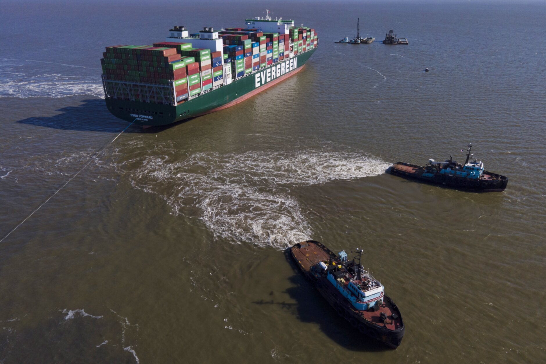 Tugboats Atlantic Enterprise (bottom center) and Atlantic Salvor (right) use ropes to tow the container ship Ever Forward, which ran aground in the Chesapeake Bay as crews attempted to refloat the ship Tuesday, March 29, 2022 make Pasadena, Md. (AP Photo/Julio Cortez)