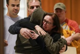 People are reunited with family members at a library after being evacuated from the scene of a shooting Friday, April 22, 2022, in northwest Washington. At least four people were shot when a gunman unleashed a flurry of bullets in the nation’s capital. The hail of gunfire led to lockdowns at several schools and left a community on edge before the suspect was found dead hours later. (AP Photo/Susan Walsh)