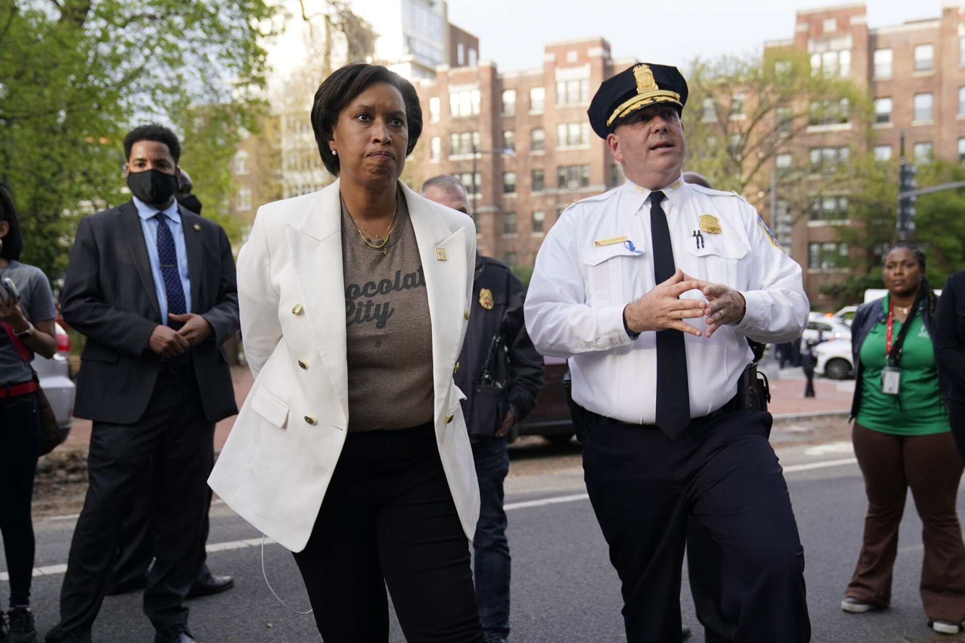 District of Columbia Mayor Muriel Bowser listens as Metropolitan Police Department assistant chief Stuart Emerman speaks near the scene of a shooting Friday, April 22, 2022, in northwest Washington. At least four people were shot when a gunman unleashed a flurry of bullets in the nation’s capital. The hail of gunfire led to lockdowns at several schools and left a community on edge before the suspect was found dead hours later.  (AP Photo/Carolyn Kaster)