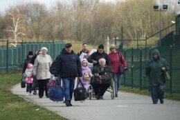 Refugees walk after fleeing the war from neighbouring Ukraine at the border crossing in Medyka, southeastern Poland, Monday, April 11, 2022. (AP Photo/Sergei Grits)