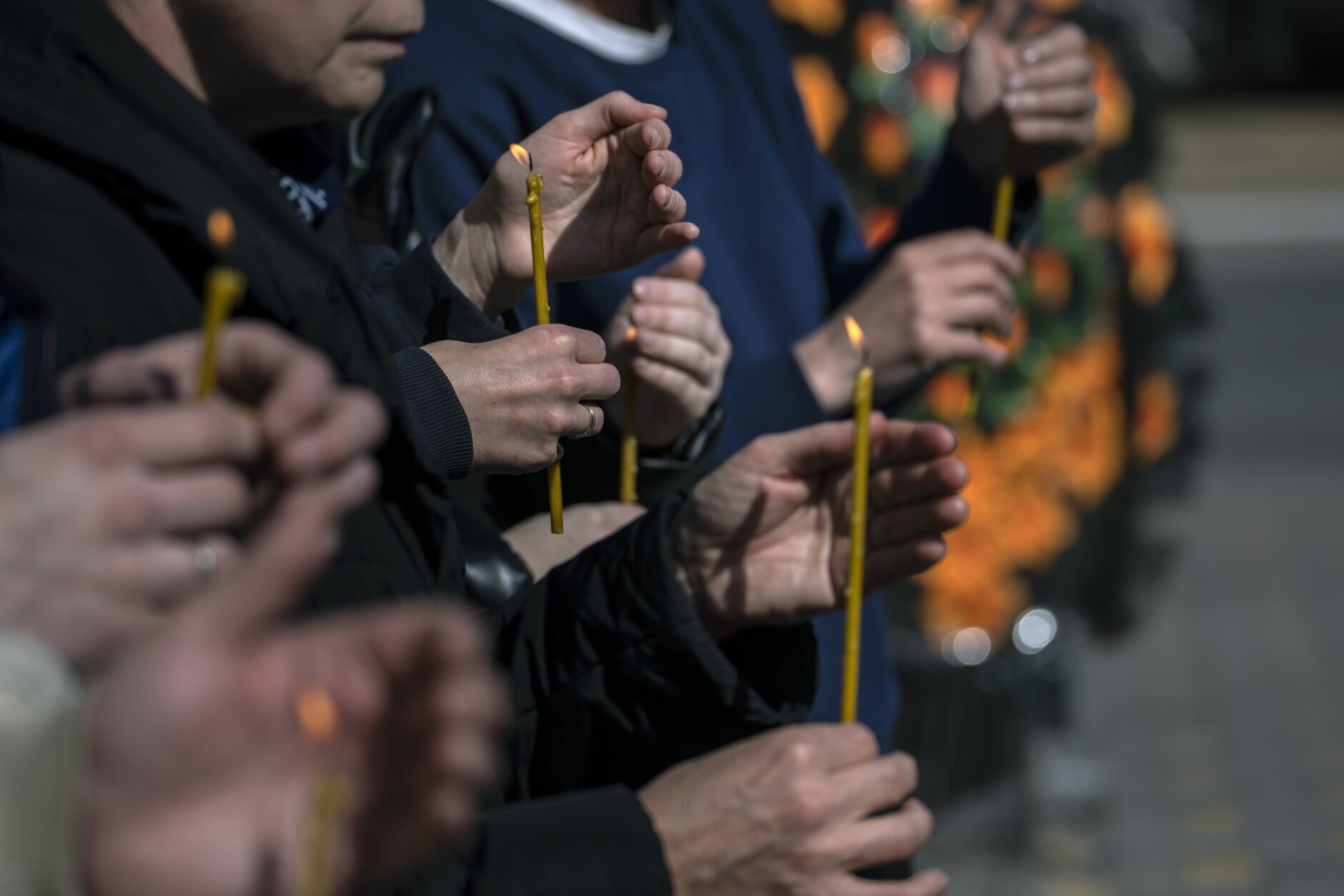 Relatives light candles while attending the funeral of Anatoliy Kolesnikov, 30, and Oleksandr Mozheiko, 31, both territorial defense soldiers who were killed by Russian, in Irpin, in the outskirts of Kyiv, Ukraine, Friday, April 15, 2022. (AP Photo/Rodrigo Abd)