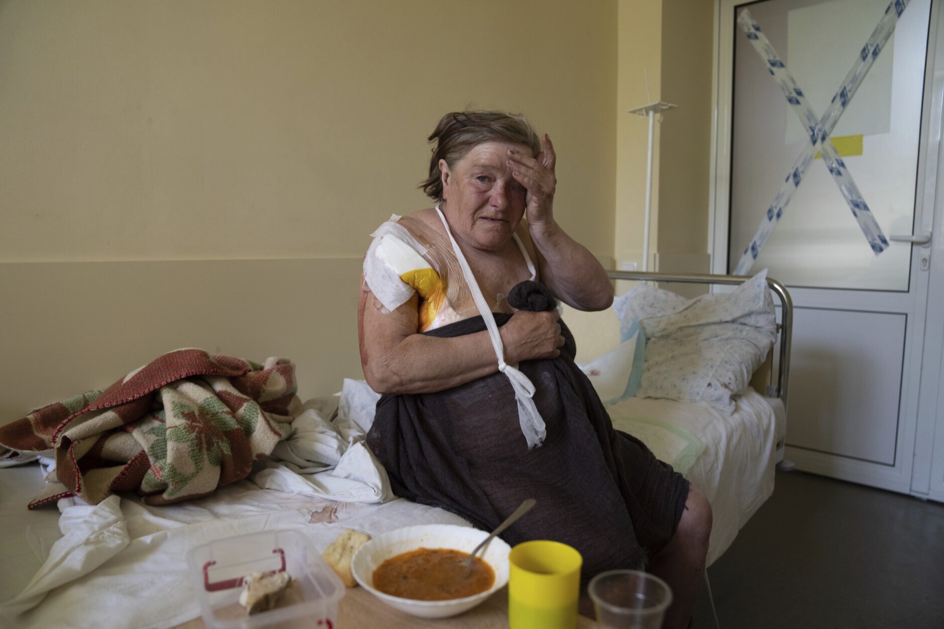 Tamara Oliynyk, 62, sits on a bed after surgery after being injured by shelling in Shandrigolovo village, at a hospital in Kramatorsk, eastern Ukraine, Tuesday, April 26, 2022. (AP Photo/Evgeniy Maloletka)