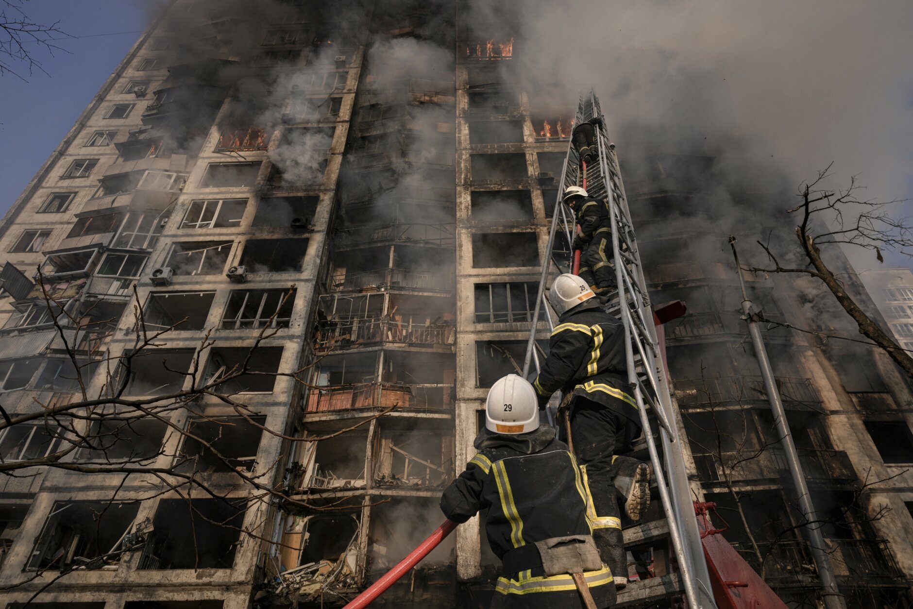 Firefighters climb a ladder while working to extinguish a blaze in a destroyed apartment building after a bombing in a residential area in Kyiv, Ukraine, Tuesday, March 15, 2022. (AP Photo/Vadim Ghirda)