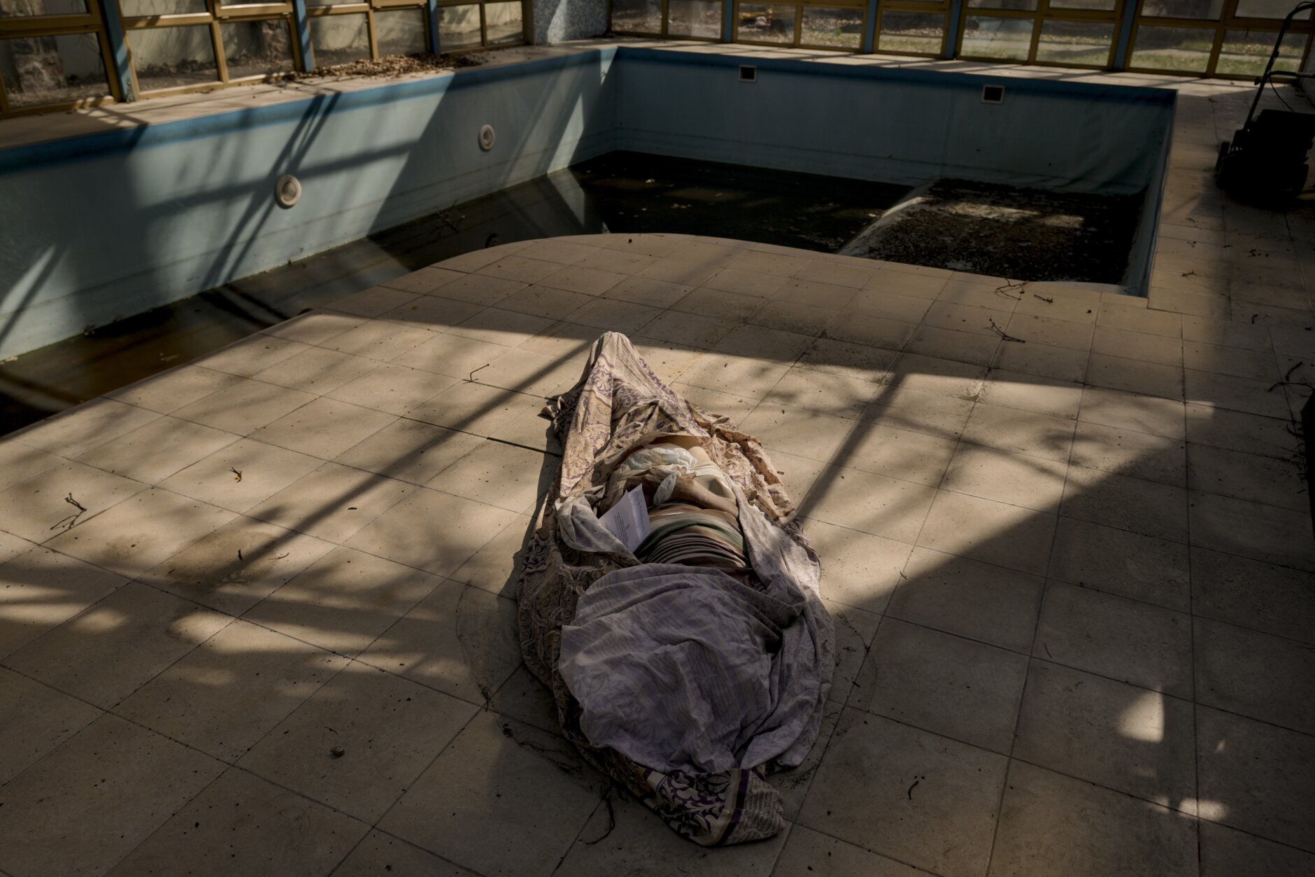 A dead body lies by the swimming pool of a home for the elderly in Bucha, Ukraine, Thursday, April 7, 2022. (AP Photo/Vadim Ghirda)