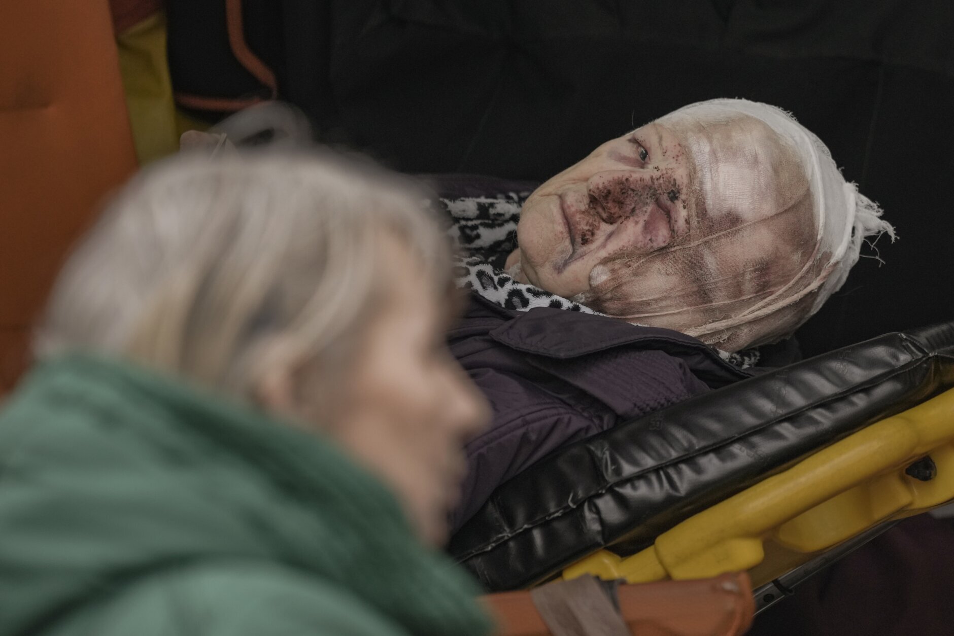 An injured woman evacuated from Irpin lies on a stretcher in an ambulance on the outskirts of Kyiv, Ukraine, Saturday, March 26, 2022. (AP Photo/Vadim Ghirda)