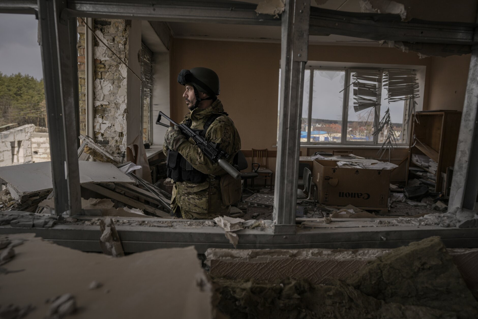 A Ukrainian serviceman stands in a heavily damaged building in Stoyanka, Ukraine, Sunday, March 27, 2022. (AP Photo/Vadim Ghirda)