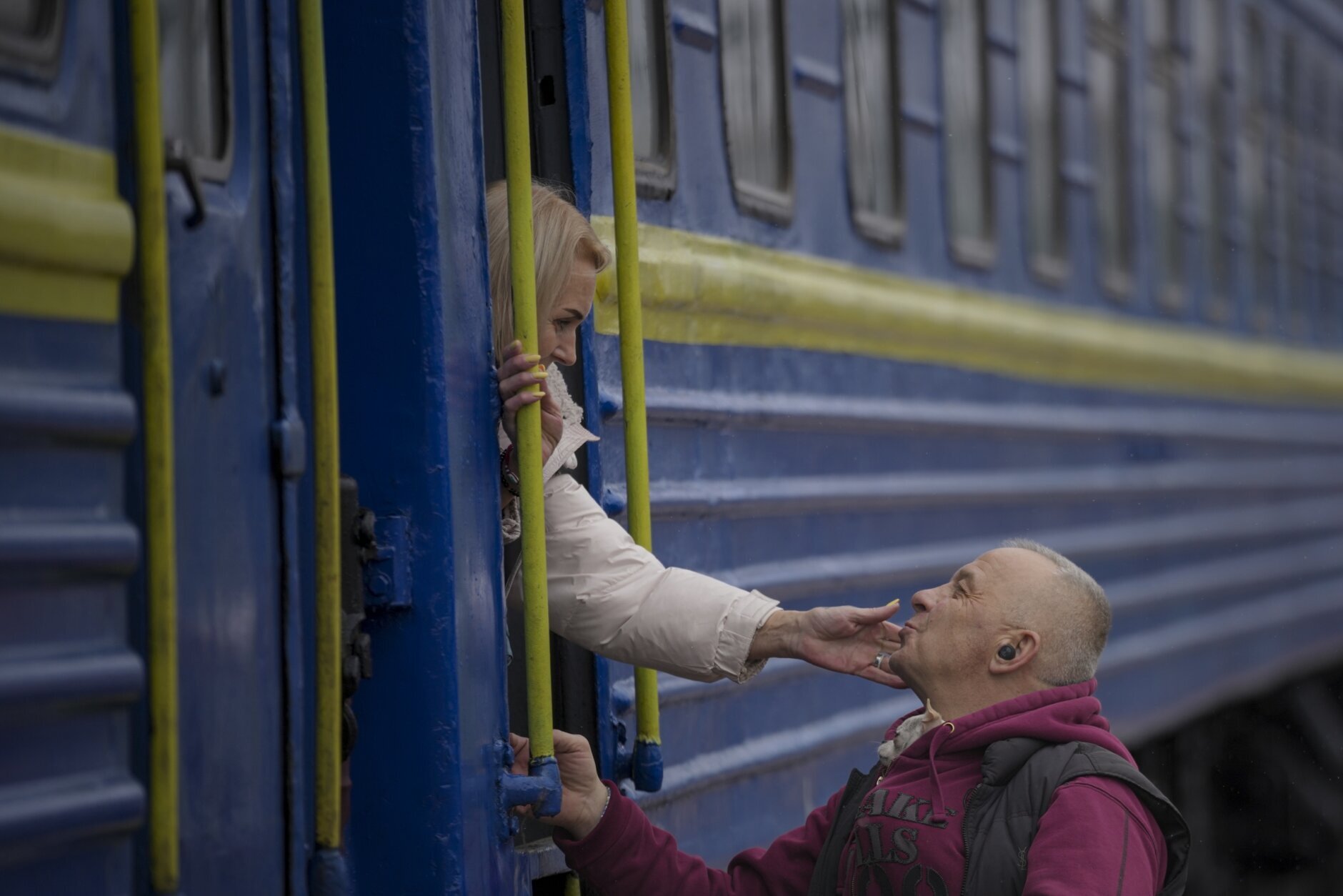 A woman bid a man good bye after boarding a Lviv bound train, in Kyiv, Ukraine, Thursday, March 3, 2022. (AP Photo/Vadim Ghirda)