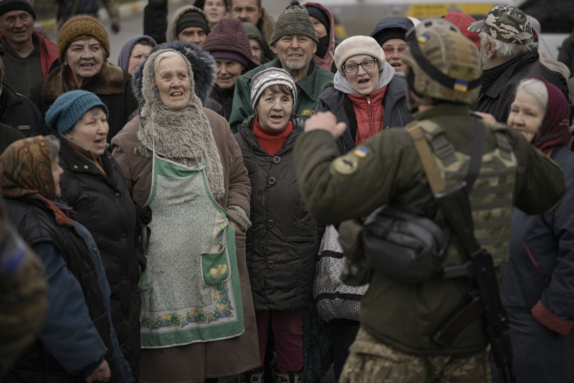 Civilians cheer along with a Ukrainian serviceman as a convoy of military and aid vehicles arrives in the formerly Russian-occupied Kyiv suburb of Bucha, Ukraine, Saturday, April 2, 2022. (AP Photo/Vadim Ghirda)