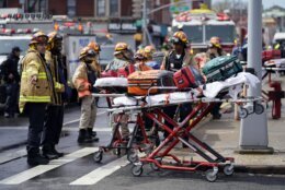 Emergency personnel gather at the entrance to a subway stop in the Brooklyn borough of New York, Tuesday, April 12, 2022. A gunman filled a rush-hour subway train with smoke and shot multiple people Tuesday, leaving wounded commuters bleeding on a platform as others ran screaming, authorities said.  (AP Photo/John Minchillo)