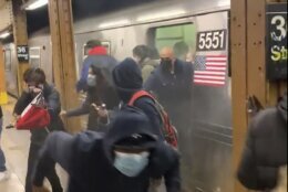 In this photo from social media video, passengers run from a subway car in a station in the Brooklyn borough of New York, Tuesday, April 12, 2022. A gunman filled a rush-hour subway train with smoke and shot multiple people Tuesday, leaving wounded commuters bleeding on a Brooklyn platform as others ran screaming, authorities said. Police were still searching for the suspect. (Will B Wylde via AP) (Will B. Wylde via AP)