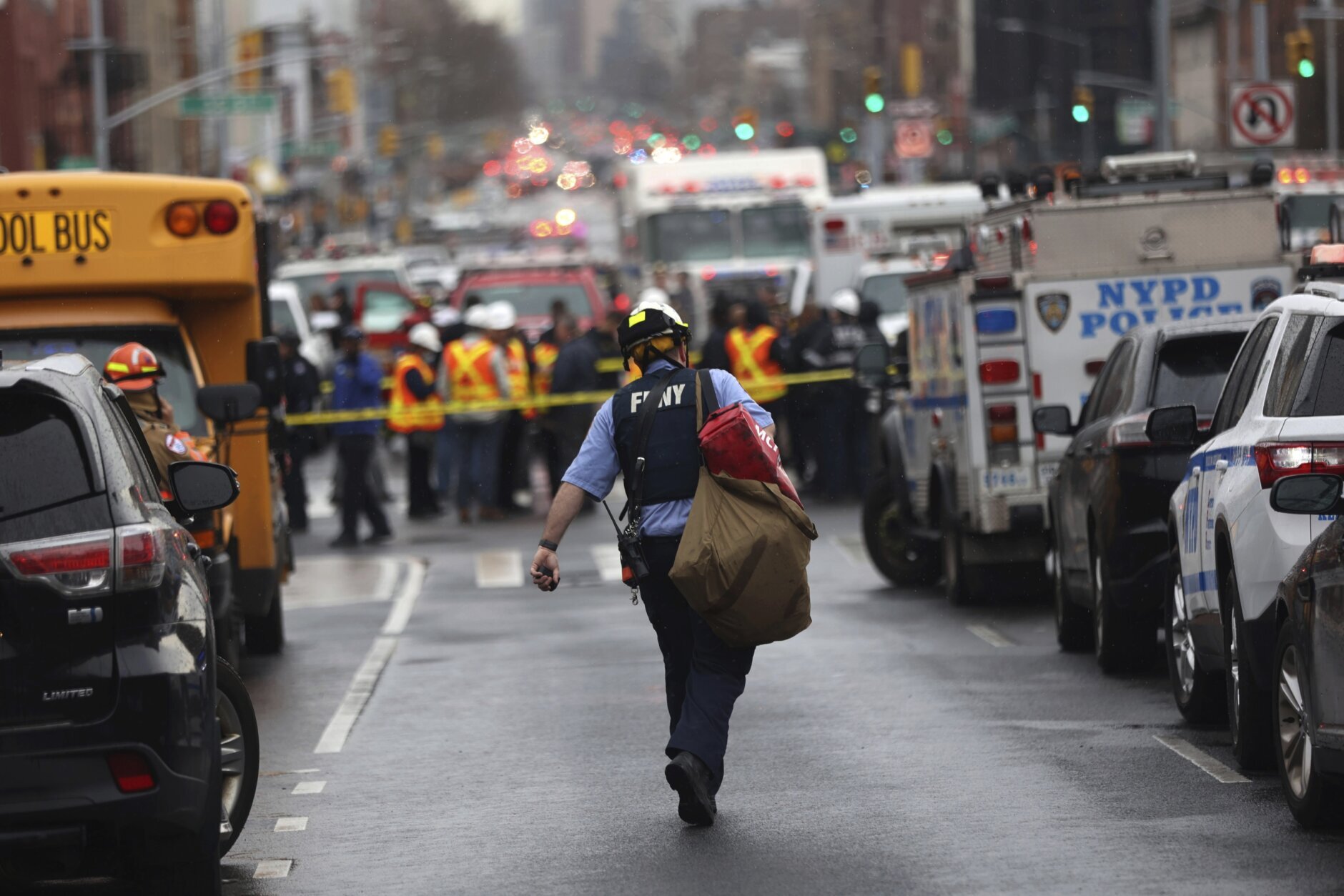 Law enforcement gather near the entrance to a subway stop in the Brooklyn borough of New York, Tuesday, April 12, 2022.  Multiple people were shot and injured Tuesday at a subway station in New York City during a morning rush hour attack that left wounded commuters bleeding on a train platform.  (AP Photo/Kevin Hagen).