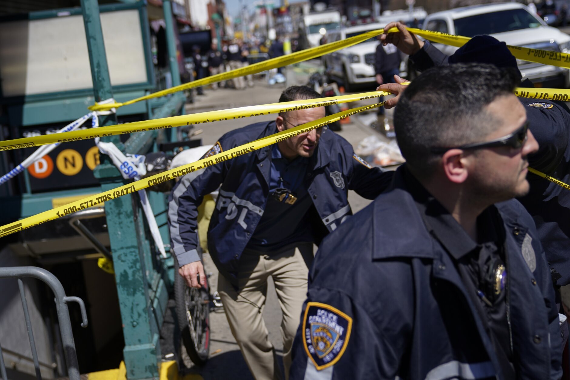 Emergency personnel gather at the entrance to a subway stop in the Brooklyn borough of New York, Tuesday, April 12, 2022. Multiple people were shot and injured Tuesday at a subway station in New York City during a morning rush hour attack that left wounded commuters bleeding on a train platform. (AP Photo/John Minchillo)
