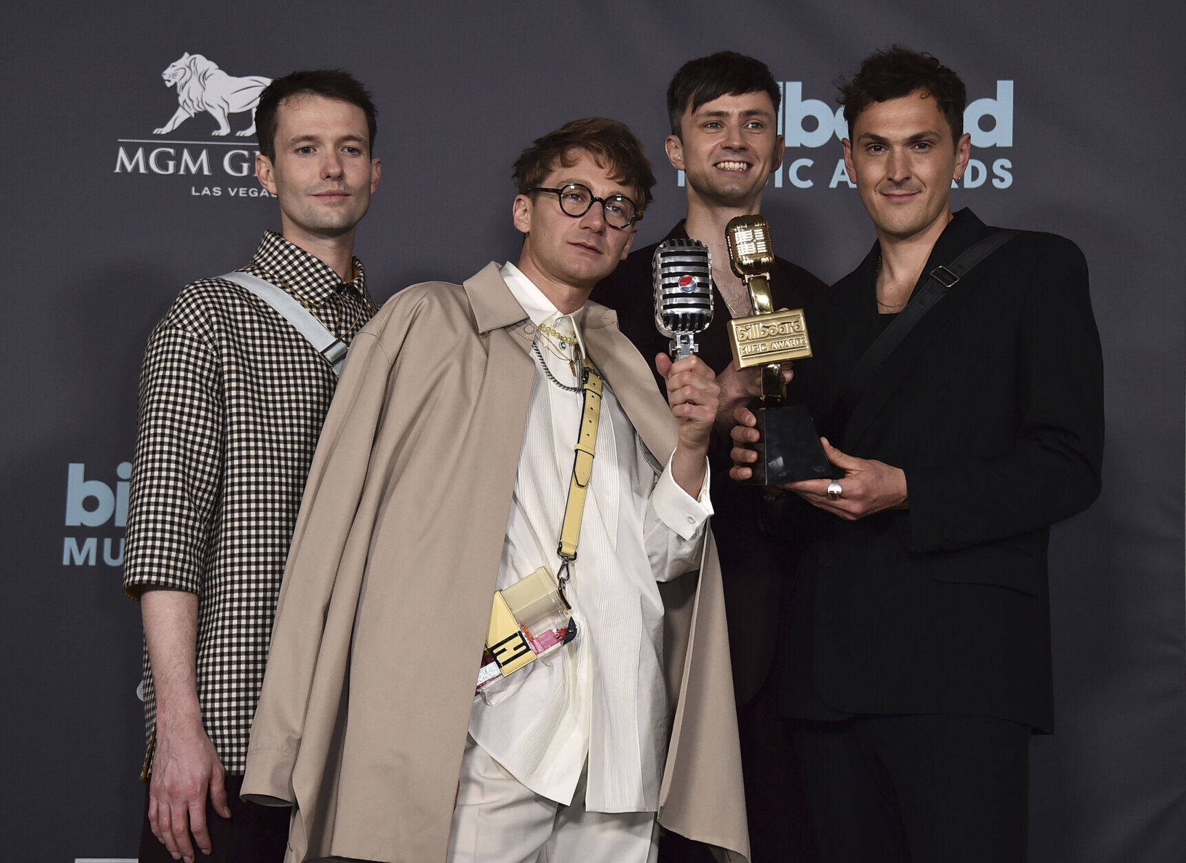 Drew MacFarlane, from left, Dave Bayley, Edmund Irwin-Singer and Joe Seaward of Glass Animals pose in the press room with the award for top rock artist and the Pepsi mic drop award at the Billboard Music Awards on Sunday, May 15, 2022, at the MGM Grand Garden Arena in Las Vegas. (Photo by Jordan Strauss/Invision/AP)