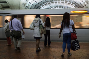 Commuters wait for a Metro train at the L'Enfant Plaza Metro station.