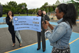 Jenelle Bryant FaceTimes her husband to tell him about her surprise Milken Educator Award. She points her phone at the huge check, held by Washington D.C. Superintendent of Education Dr. Christina Grant (left) and Dr. Shavonne Gibson, OSSE assistant superintendent, to show him that it bears her new last name (the two married recently). 